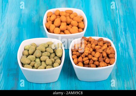 Mix di noci in wasabi e pastella spezia su sfondo di legno. Foto Stock