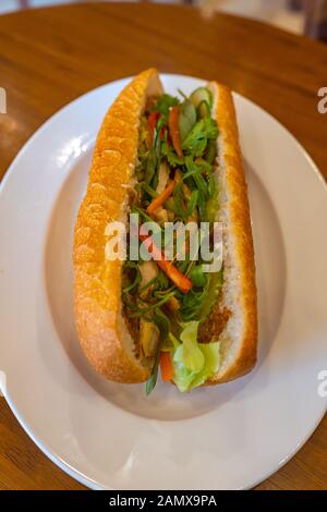 Il vietnamita delizioso sandwich di pollo sulla piastra bianca - Banh Mi Foto Stock