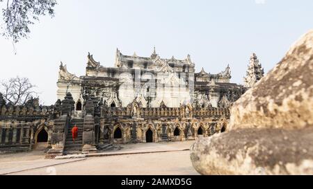 Inwa, Myanmar - Aprile 2019: monaco buddista a piedi su per le scale fino a me nu Monastero di mattoni nella regione di Mandalay. Foto Stock