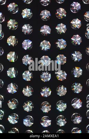 Grandi cristalli Swarovski iridescenti contro una massa nera Foto Stock