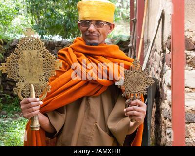 Sacerdote a Bahir Dar che mostra un importante crocifisso fuori Kebran Gabriel monastero, Kebran Gabriel Island, Lago Tana. Etiopia. Foto Stock