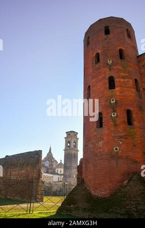 Vista verticale di una torre della Porta Palatina (1° secolo) con la Cappella della Sacra Sindone in background in una giornata di sole, Torino, Piemonte, Italia Foto Stock