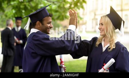 Gli studenti laureati con diplomi di parlare ad alta fiving ogni altra convocazione giorno Foto Stock