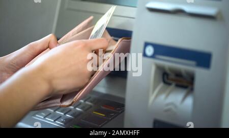 Mani lady mettere rubli russi nel portafoglio, contanti ritirati da ATM, turismo Foto Stock