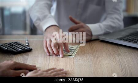 Impiegato bancario che dà credito al cliente in dollari, spese personali, deposito, risparmi Foto Stock