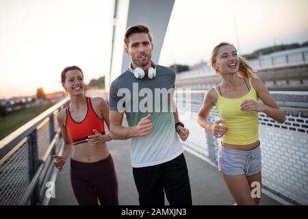 Montare atletico persone che esercitano e correndo insieme all'aperto Foto Stock