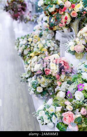 Bouquet di rose artificiali con foglie, interior design righe liscia di mazzi nel negozio di fiori, decorazione artificiale bianco fiore lilla bouquet di rose Foto Stock