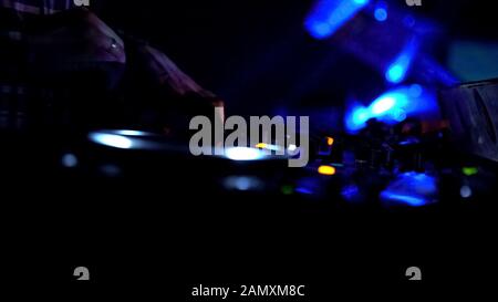 Mani di dj maschio che accende i comandi su apparecchiature audio, la riproduzione di musica in discoteca Foto Stock