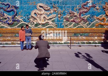 Ein Schnappschuß für das Familienalbum vor historischer Kulisse a Pechino, Cina um 1990. Un'istantanea per l'album fotografico di famiglia di fronte a un drago storico fissato a Pechino, Cina intorno al 1990. Foto Stock