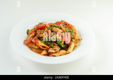 Penne pasta con una ricca salsa di pomodoro e fette di British insaccato di maiale conditi con formaggio Cheddar, cibo italiano Foto Stock