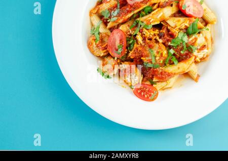 Penne pasta con una ricca salsa di pomodoro e fette di British insaccato di maiale conditi con formaggio Cheddar, cibo italiano Foto Stock