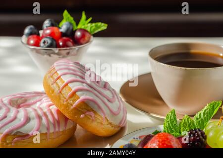 Ciambella con aroma di lampone riempimento, guarnita con bianco e rosa, glassa dolce ciambella Foto Stock