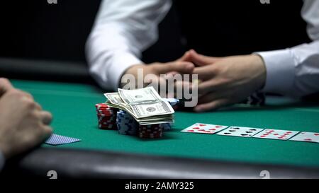 Azzardato giocatore di poker che va tutto dentro, scommettendo tutti i chip e soldi, dipendenza di gioco d'azzardo Foto Stock