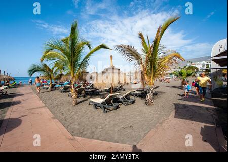 Canary ISLAND TENERIFE, SPAGNA - 26 dicembre 2019: I turisti sono distesi e rilassanti tra palme e lettini sulla spiaggia chiamata playa de torviscas. Foto Stock