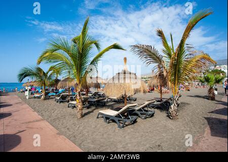 Canary ISLAND TENERIFE, SPAGNA - 26 dicembre 2019: I turisti sono distesi e rilassanti tra palme e lettini sulla spiaggia chiamata playa de torviscas. Foto Stock