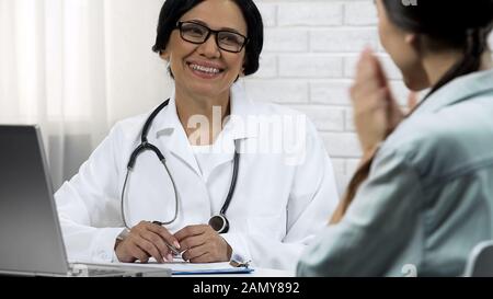 Medico femminile che informa il paziente del recupero, buoni risultati del trattamento Foto Stock