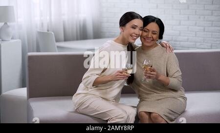 Attraenti donne asiatiche abbracciando, bevendo vino bianco, festa della gallina, celebrazione Foto Stock