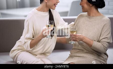 Donne bevendo vino bianco e chiacchierando, sostegno e comunicazione, celebrazione Foto Stock