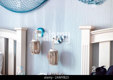 Interno di una camera di albergo. In stile retrò lampade pendenti tra i letti con tema oceanico Foto Stock