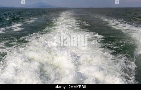 Onde da una barca a vela in mare delle Andamane al largo della costa della Thailandia a Krabi town Foto Stock