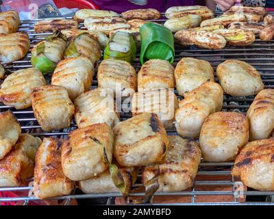 Grigliata cambogiano di riso appiccicoso banana alla street market alimentare Foto Stock