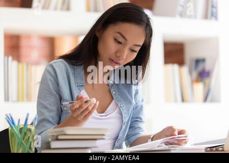 Gli studenti asiatici focalizzati si preparano all'esame in biblioteca Foto Stock