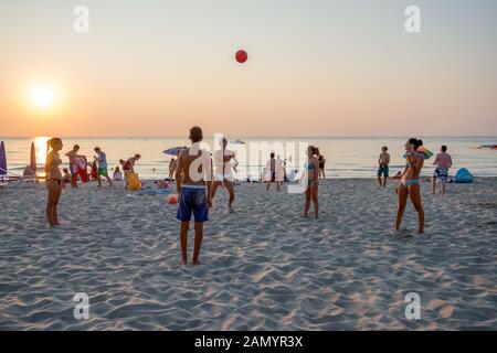 Il turista a godere la spiaggia di Cefalù al tramonto. Centro storico di Cefalu è un importante destinazione turistica in Sicilia. Foto Stock