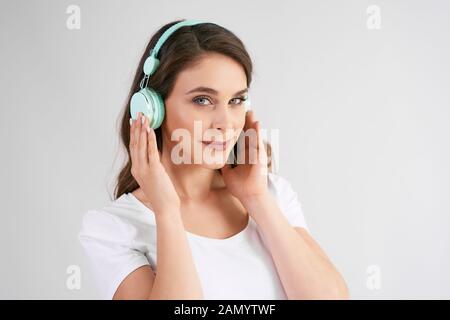 Ritratto di giovane donna con cuffie che ascoltano la musica Foto Stock