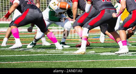 Il calcio è in aria dopo il centro scatta al quarterback del fucile durante una scuola di gioco di calcio. Foto Stock