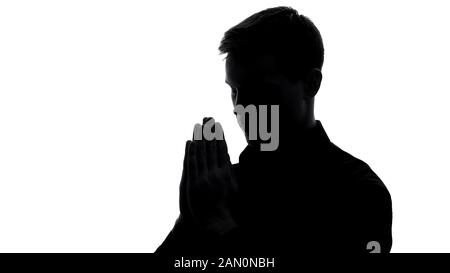 L'ombra del giovane prega, chiede perdono, rituale religioso, ringraziamento Foto Stock