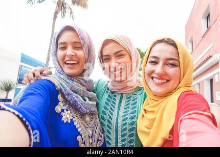 Islamic giovani amici prendendo selfie con la fotocamera dello smartphone per esterno - Happy arabian ragazze divertirsi con la nuova tecnologia di tendenza - Amicizia e millenn Foto Stock