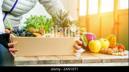 Venditore di frutta donna con diversi tipi di frutta e verdura in negozio - Lavoratore preparare frutta carta ecologica carrello - vegetariano e vegano concetto - Foc Foto Stock