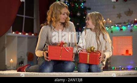 Madre e figlia che preparano le scatole del regalo il Natale, atmosfera di festa Foto Stock