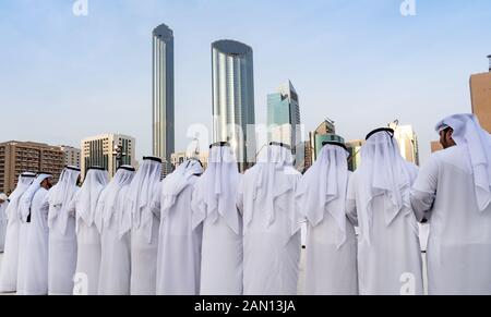 Gli uomini degli Emirati suonano lo Yowla, una danza tradizionale nel patrimonio degli Emirati Arabi Uniti nel centro di Abu Dhabi Foto Stock