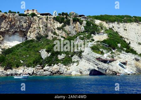 Agia Nikolaos, Grecia - 25 Maggio 2016: persone non identificate, barca e grotte intorno a capo Skinari sull'isola di Zante Foto Stock