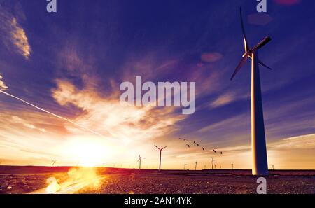 Parco eolica e mulini a vento in paesaggio al tramonto e campi Foto Stock