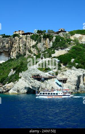 Agia Nikolaos, Grecia - 25 Maggio 2016: persone non identificate sulla barca e grotte intorno a capo Skinari sull'isola di Zante Foto Stock