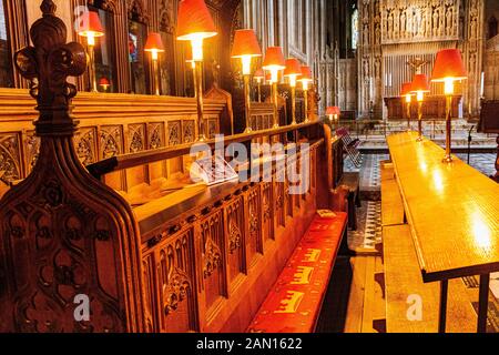 Dettaglio Delle Bancarelle del Coro nella Cattedrale di Bristol con luci e L'Altare maggiore sullo sfondo Prima di Evensong: La Cattedrale di Bristol. Foto Stock