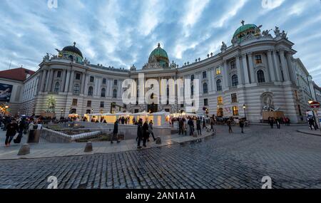 Vienna, AUSTRIA - 30 DICEMBRE 2019: I turisti camminano al mercatino di Natale di fronte al Palazzo Hofburg in piazza Michaelerplatz il 30 dicembre 2019 a Vienna, Austria. Foto Stock