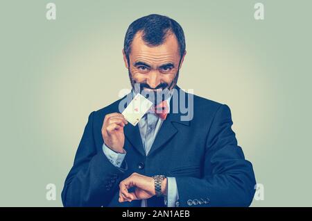 Uomo d'affari con bearded che mostra la carta di asso e guarda, guardando verso te la macchina fotografica. Vinci ora. Il momento giusto per l'azienda, prendere le decisioni. Concetto di gioco d'azzardo. Opportun Foto Stock