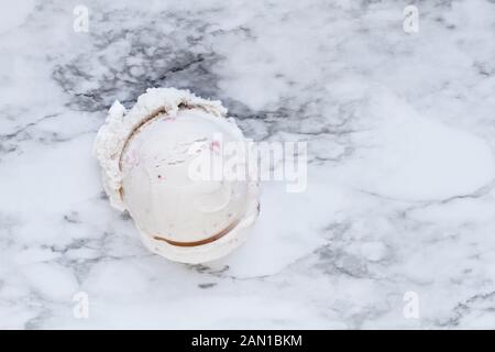 Vista Flatlay di uno scoop di rosa gelato alla fragola oltre a marmi bianchi e grigi texture di sfondo. Vista dall'alto. Foto Stock