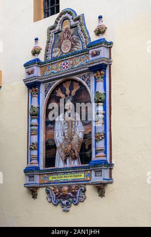 Un tradizionale di placca in piastrelle sulla parete del xviii secolo Iglesia de San Juan de la Palma in Calle Feria, Siviglia. Foto Stock