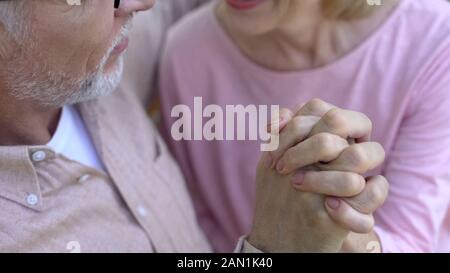 Romantico coppia in pensione dita incrociate, tenendo le mani, felice nonni Foto Stock