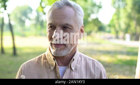 Bel colore grigio-uomo dai capelli godendo weekend nel parco, felice pensionato maschio outdoor Foto Stock