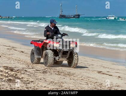 Una guardia di sicurezza turistica specializzata Corps {CESTUR}, pattuglie costiere il nastro su un veicolo speciale Punta Cana , Repubblica Dominicana Foto Stock