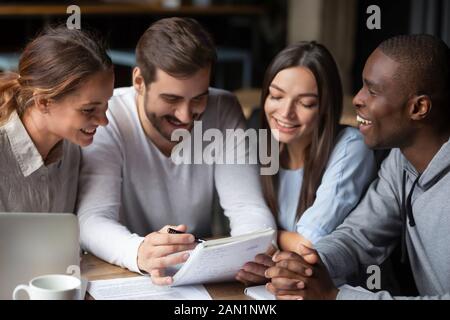 Gli studenti internazionali felici si riuniscono in caffè studiando insieme Foto Stock