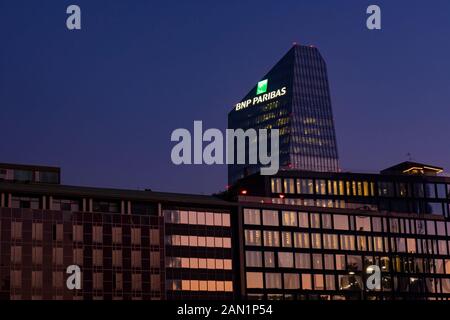 Edificio in vetro sede della banca francese BNP Paribas con il logo illuminato di segno al tramonto. Milano, Italia. Foto Stock