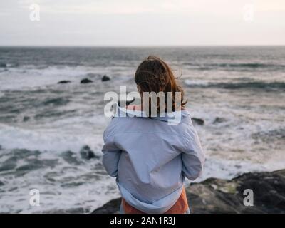 Giovane donna che guarda l'oceano Foto Stock