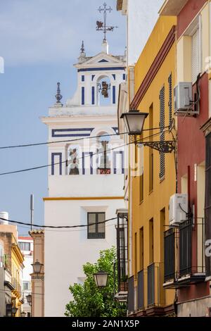 Il campanile imbiancato di Iglesia Santiago nella Plaza de Jesus de la Redencion contrasta con i colorati appartamenti di Calle Santiago Foto Stock