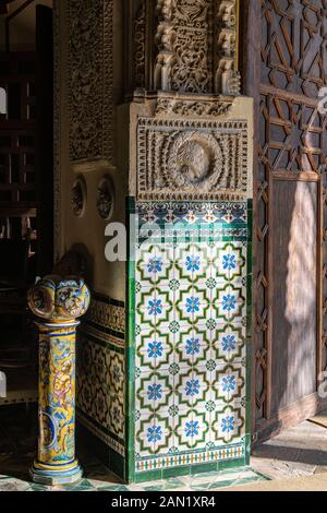 La testa di una donna addobbata scolpita sopra la decorazione colorata delle piastrelle in ceramica azulejos all'ingresso dell'Antecapilla del Palacio de las Dueñas Foto Stock